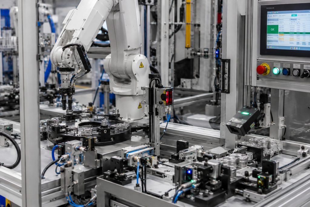 Detailná montážna stanica s robotickým manipulátorom, senzorikou, PLC riadením a automatizovanou kontrolou kvality v modernej priemyselnej výrobe.